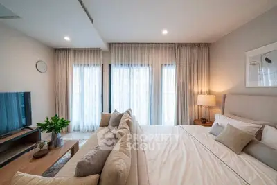 Luxurious bedroom with elegant decor and natural light, featuring a cozy bed and stylish furnishings.