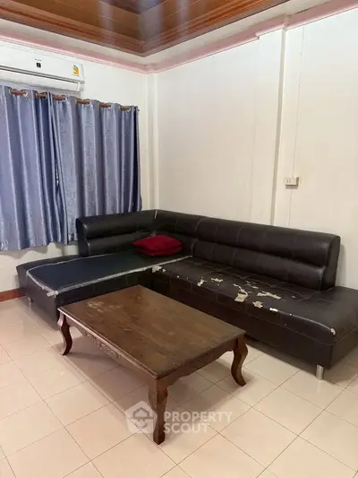 Cozy living room with sectional sofa and wooden coffee table, perfect for relaxation.