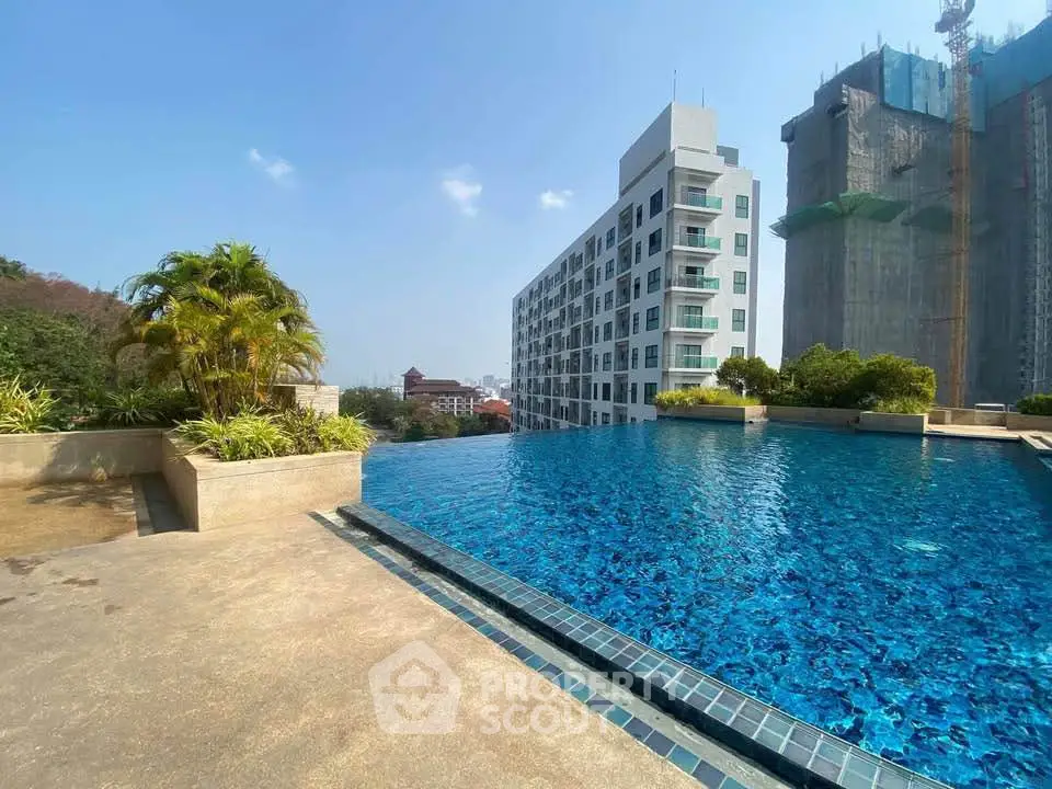 Luxurious rooftop infinity pool with stunning cityscape views and modern apartment building.