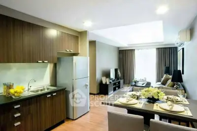 Modern open-plan living room and kitchen with stylish decor and natural light.
