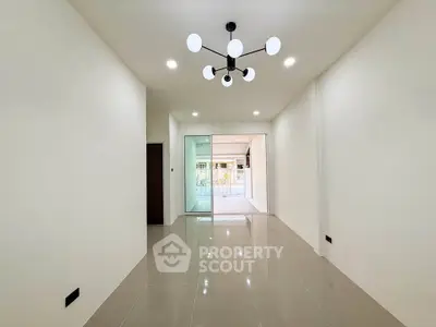 Spacious modern living room with sleek lighting and glossy tiled floors
