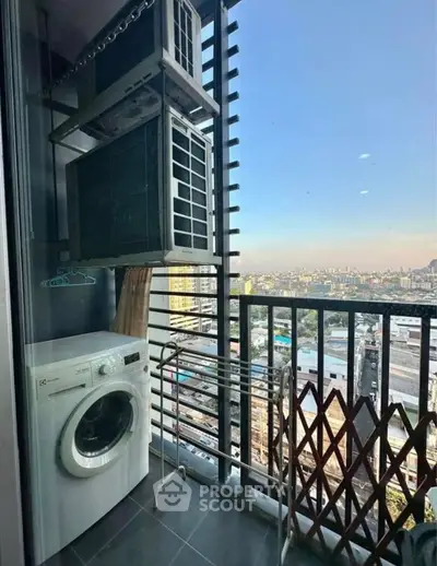High-rise balcony with city view, featuring washing machine and air conditioning units.
