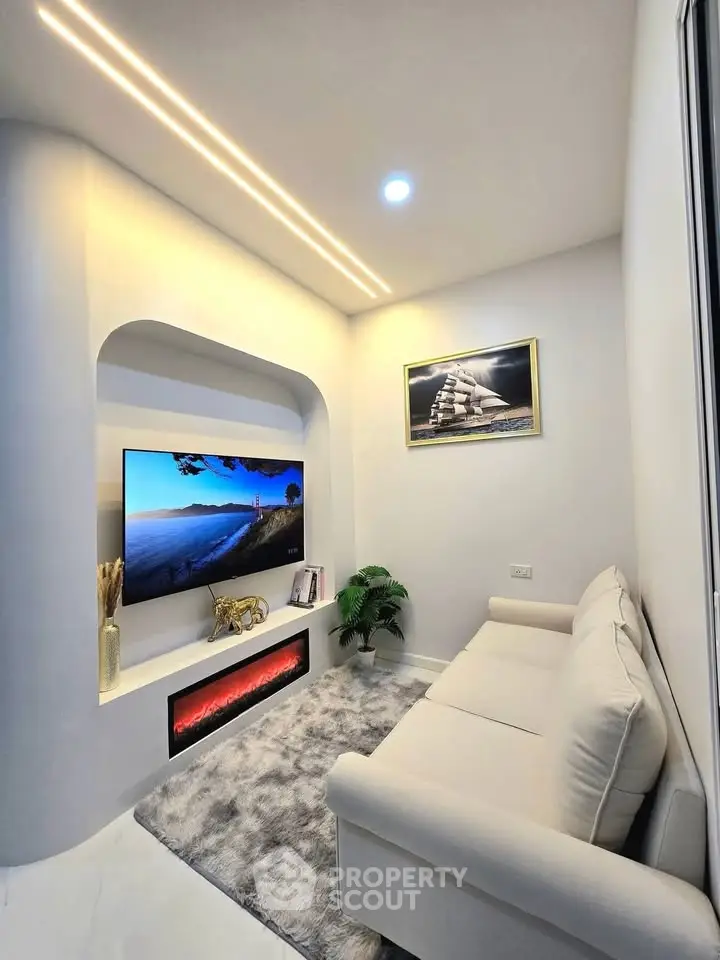 Modern living room with sleek design, featuring a cozy sofa, wall-mounted TV, and ambient lighting.
