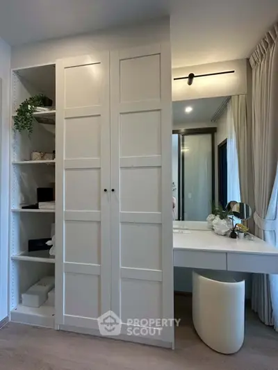 Modern bedroom with elegant white wardrobe and stylish vanity area, perfect for contemporary living.