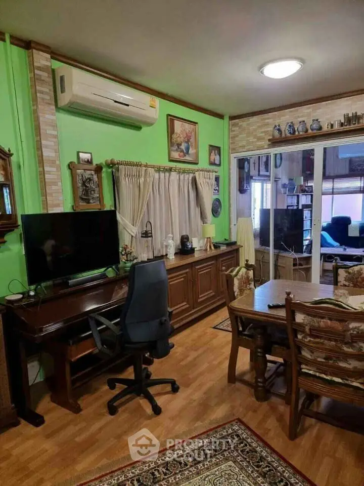 Charming living room with vibrant green walls and cozy decor, perfect for relaxation and entertainment.