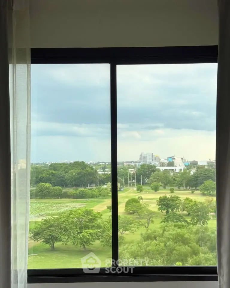 Stunning window view of lush greenery and cityscape, perfect for nature lovers.