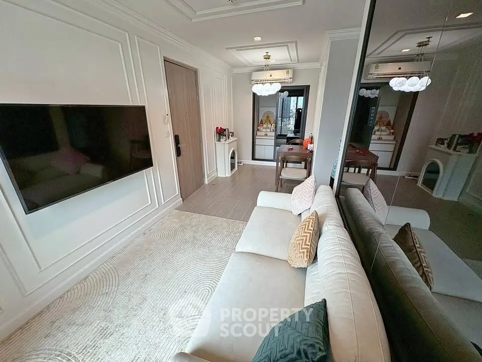 Elegant living room with modern decor and large wall-mounted TV in a stylish apartment.