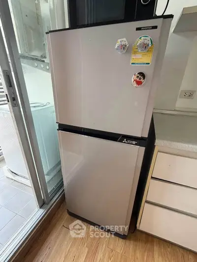 Modern kitchen with sleek refrigerator and wooden flooring