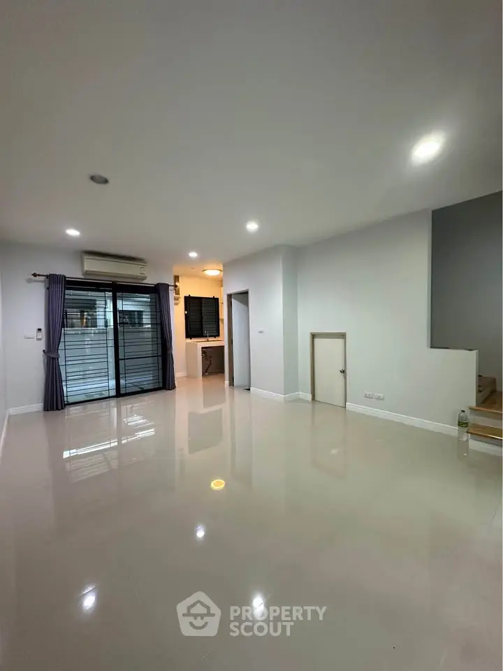 Spacious modern living room with glossy floors and ample natural light