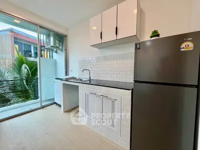 Modern kitchen with sleek appliances and balcony view in a stylish apartment.