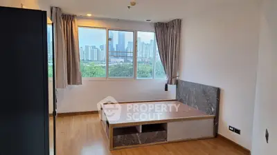 Spacious bedroom with city view and modern wooden flooring.