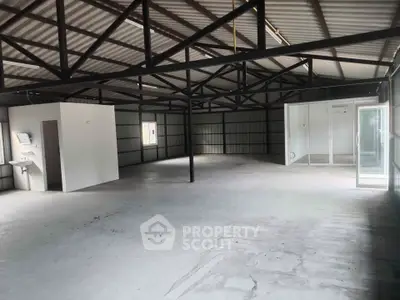 Spacious industrial warehouse with high ceilings and ample natural light.