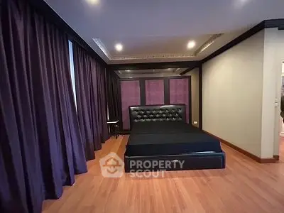 Luxurious bedroom with elegant dark decor and hardwood flooring
