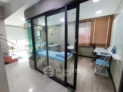 Modern office space with glass partition and sleek furnishings