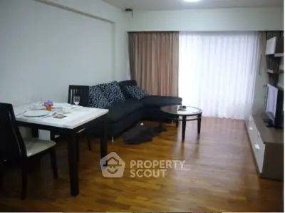 Modern living room with wooden flooring, cozy sofa, and dining area in open layout apartment.