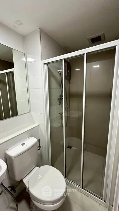 Modern bathroom with glass shower enclosure and sleek fixtures.