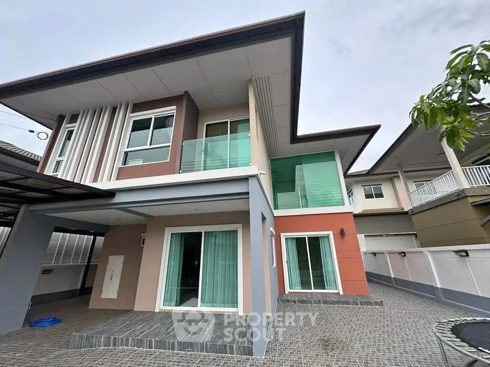 Modern two-story house with large windows and spacious driveway