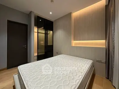 Modern bedroom with elegant lighting and wooden accents, featuring a comfortable mattress and sleek design.