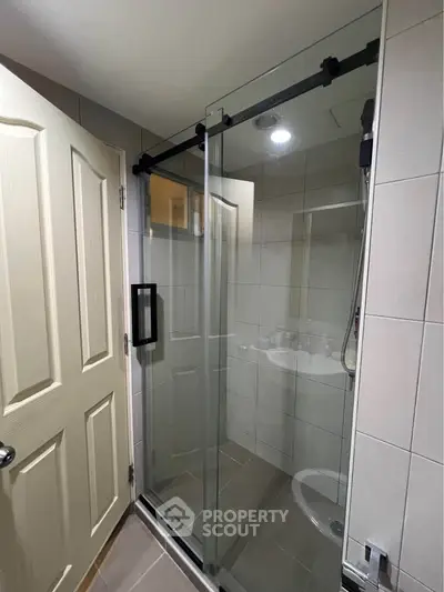 Modern bathroom with sliding glass shower door and sleek tile design