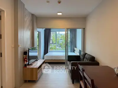Modern studio apartment with open layout, featuring a cozy living area and a bedroom with large windows.