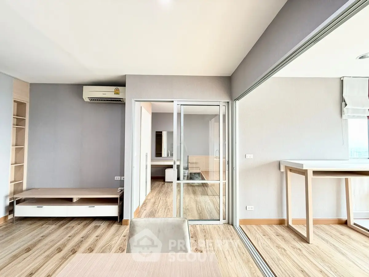 Modern open-plan living space with sliding glass doors and wood flooring