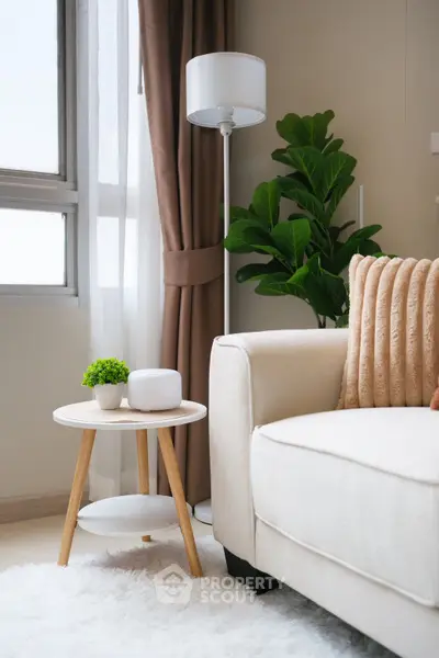 Stylish living room with cozy sofa, modern lamp, and lush plant for a serene ambiance.