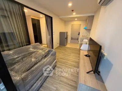 Modern living room with sleek furniture and open kitchen layout in a stylish apartment.