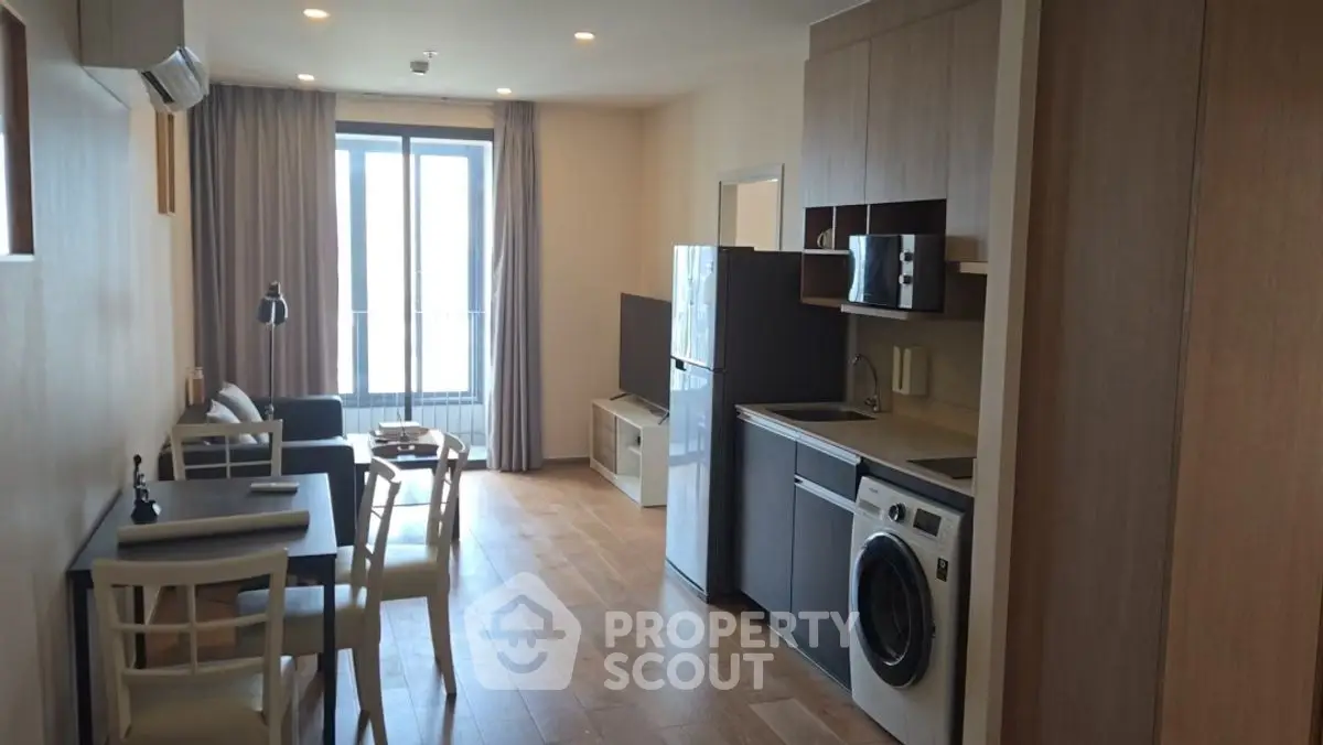 Modern apartment interior with open layout, featuring kitchen and living area with natural light.