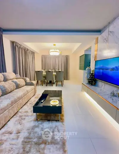 Luxurious living room with plush sofa, elegant dining area, and modern decor in a stylish apartment.