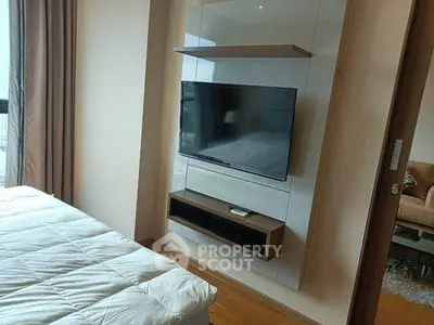 Modern bedroom with wall-mounted TV and cozy bed setup