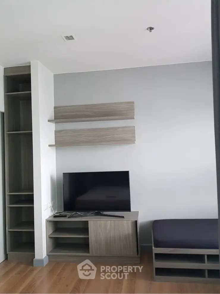 Modern living room with sleek TV stand and minimalist shelving in a stylish apartment.