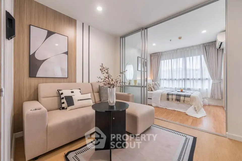 Modern living room with stylish decor and cozy bedroom view in open layout apartment.