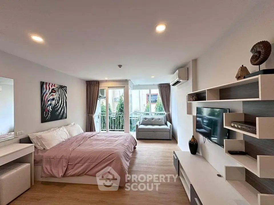 Modern bedroom with stylish decor and balcony view in a cozy apartment.