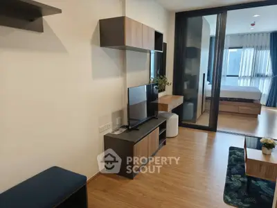Modern living room with sleek furniture and view into a stylish bedroom, featuring wooden flooring and contemporary decor.