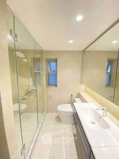 Modern bathroom with glass shower and sleek fixtures in luxury apartment