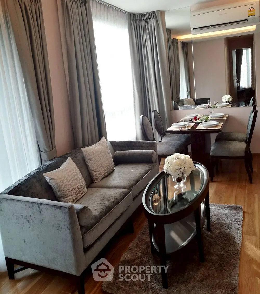 Elegant living room with plush sofa, dining area, and stylish decor in modern apartment.