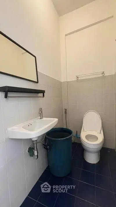 Compact bathroom with modern fixtures and blue tile flooring