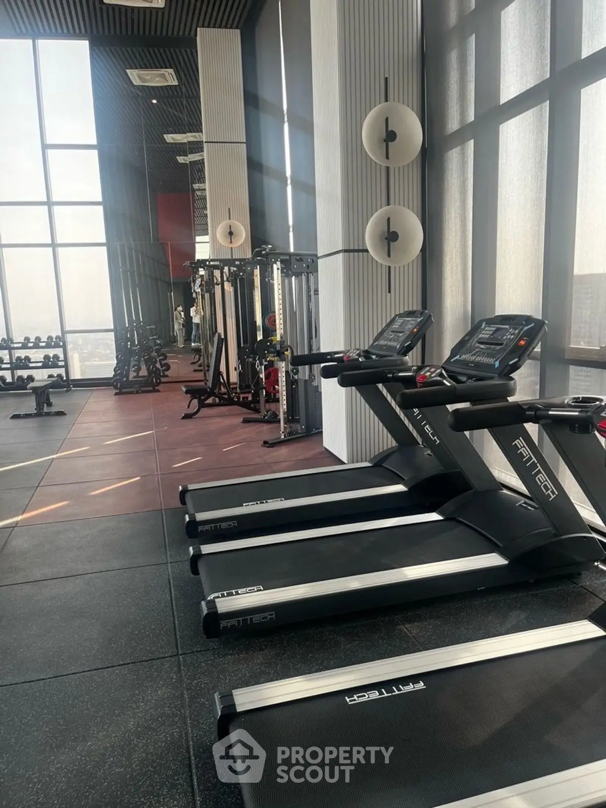 Modern gym with treadmills and weightlifting equipment in a high-rise building