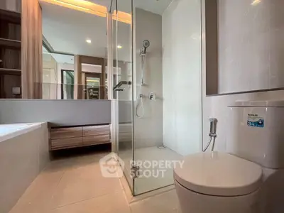 Modern bathroom with glass shower and sleek fixtures in luxury apartment