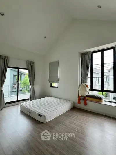 Spacious bedroom with large windows and balcony access in modern home