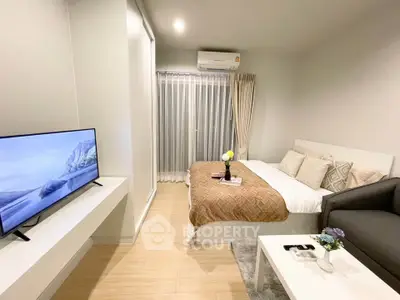 Modern studio apartment with cozy bed, sleek TV, and stylish decor in a bright, inviting space.