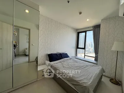 Modern bedroom with city view, featuring a cozy bed and stylish decor.