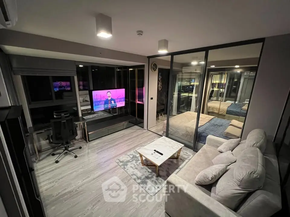 Modern open-plan living room with glass partition, cozy sofa, and stylish decor in a contemporary apartment.