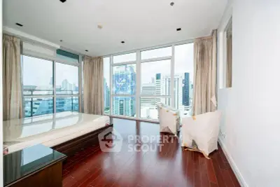 Luxurious bedroom with stunning city view and floor-to-ceiling windows in modern high-rise apartment.