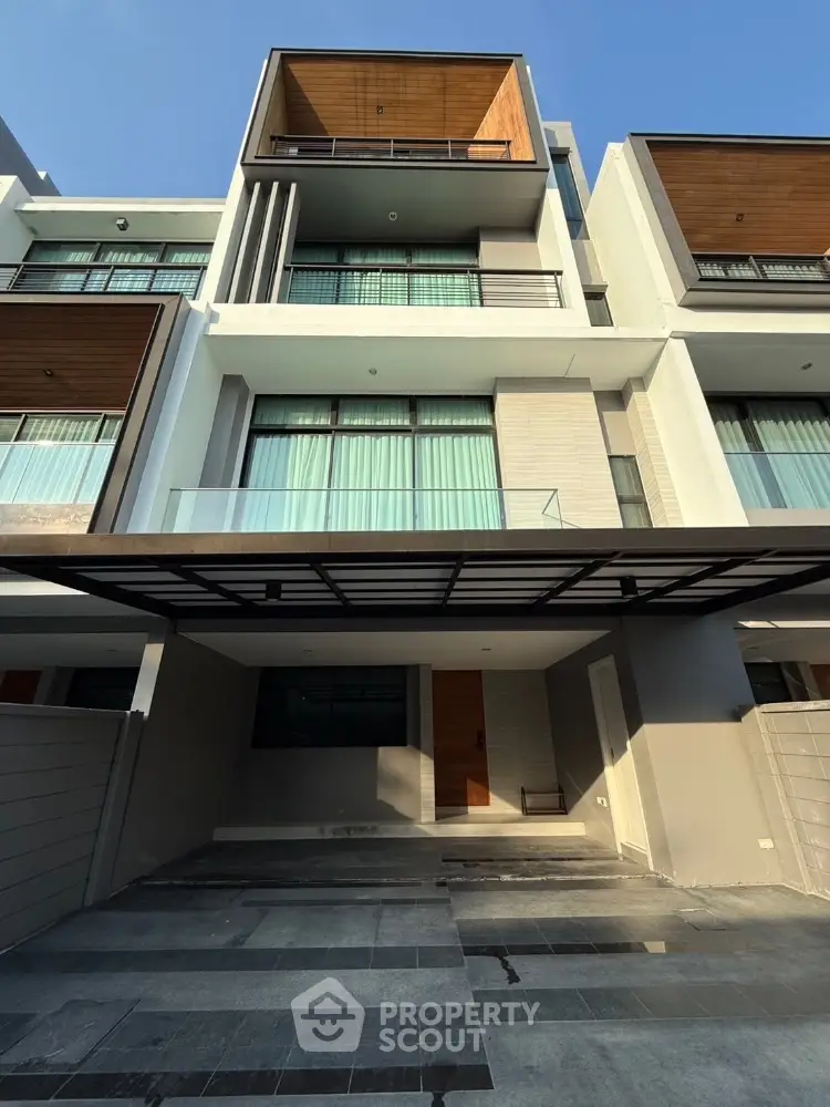 Modern multi-story townhouse with sleek design and spacious driveway