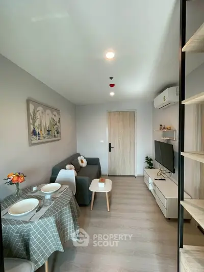 Modern living room with cozy seating and dining area, featuring stylish decor and natural light.