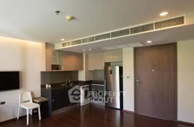 Modern kitchen with sleek appliances and wooden flooring in a stylish apartment.