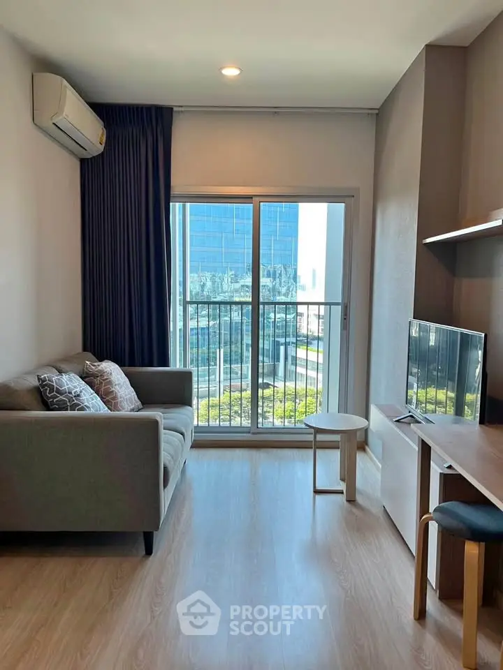 Modern living room with city view, cozy sofa, and sleek TV setup.