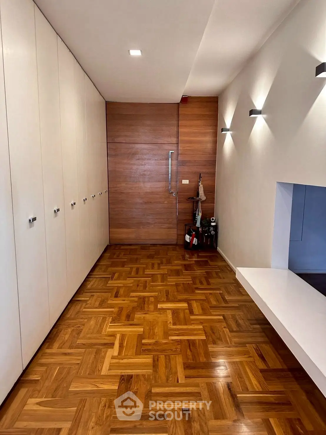 Spacious hallway with elegant parquet flooring and modern lighting