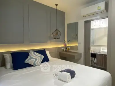Modern bedroom with stylish decor and air conditioning, featuring a cozy bed and elegant lighting.